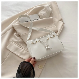 Detailed view of the drawstring metal eyelets and premium PU leather on the beige bag