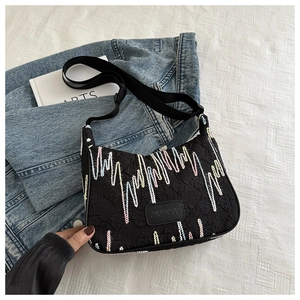 Flat lay of nylon shoulder bag featuring colorful embroidery and textured fabric