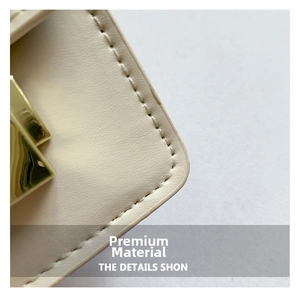 Detail of cream leather texture with neat stitching and glossy gold metal lock clasp