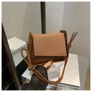 Details der braunen Vintage-Tasche mit gewebter Textur und dekorativem geknotetem Riemen