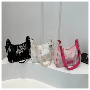 Detailed view of three colored embroidered shoulder bags with wide woven adjustable straps