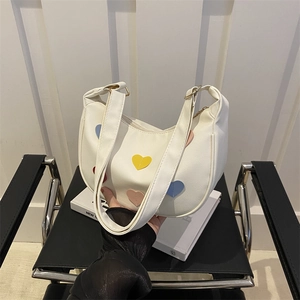 White crescent underarm bag with colorful heart patches and adjustable shoulder strap
