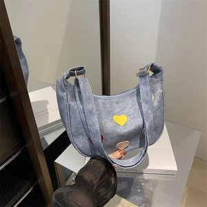 Light blue denim hobo bag featuring colorful leather heart patches and gold buckles