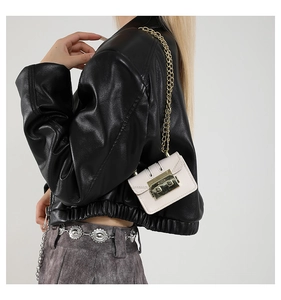 Detail of white mini square bag with gold lock and chain strap on a black leather jacket