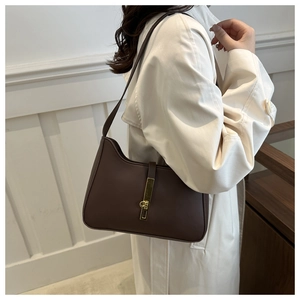 Gros plan d'un sac hobo en cuir marron foncé avec boucle dorée et bandoulière élégante