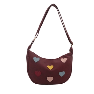 Fashionable burgundy crescent bag with colorful heart patches and adjustable strap