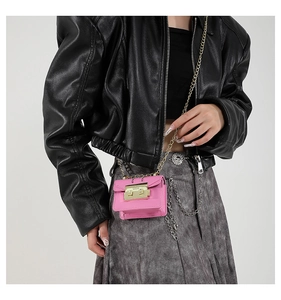 Detailed view of pink mini chain crossbody bag worn with a black leather jacket