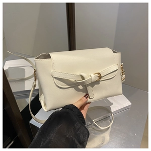 Detail of off-white crossbody bag featuring golden vintage buckle and fine leather strap