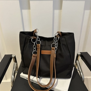 Large black tote bag for women with brown leather straps and metal chain details