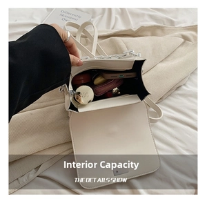 Detail showing internal capacity of the cream crossbody bag with phone and cosmetics