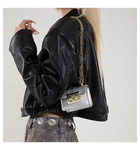 Detailed macro view of a silver metallic mini chain bag with a gold push-lock closure