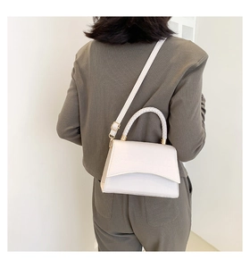 White crocodile pattern square handbag with woven handle worn by model on shoulder