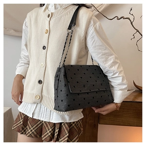 Sac bandoulière en toile avec broderie nœud et chaîne en métal dans une pièce