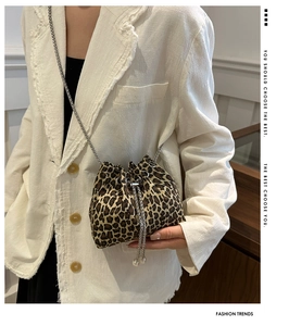 Detail of leopard print bucket bag with silver drawstring and metal chain strap