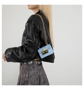 Close-up of a light blue leather chain bag featuring a square gold-tone metal clasp lock