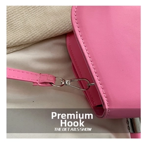 Détail du sac en cuir rose montrant le crochet en métal argenté et les coutures nettes