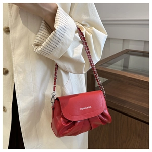 Détail du sac nuage rouge plissé avec chaîne argentée et logo mode blanc