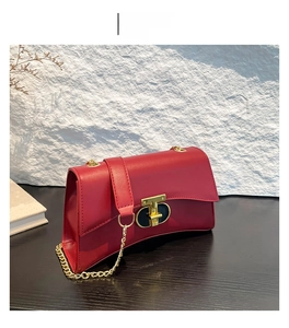 Détail du sac vintage rouge avec une boucle métallique dorée élégante et chaîne dorée