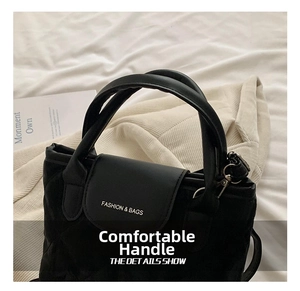 Detail of black quilted nylon bucket bag featuring white FASHION logo and soft handles