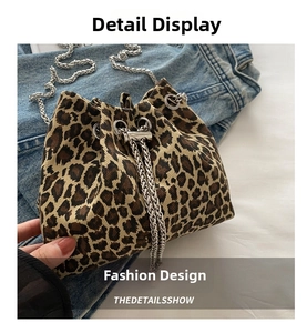 Detail of leopard print bucket bag with silver chain strap on denim jacket background