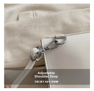 Close-up of the adjustable strap and silver metal hardware on a white leather backpack