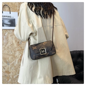 Detail view of the retro contrast printed shoulder bag with metallic M-buckle closure