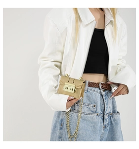 Detailed close-up of the khaki mini chain bag with gold square metal lock on a model