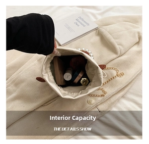 Detail of the white crossbody bag interior showing capacity for cosmetics and pearl handle