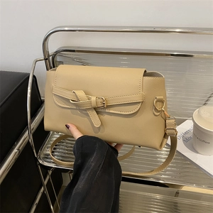 Minimalist beige crossbody bag with flap and buckle in a chic autumn fashion style