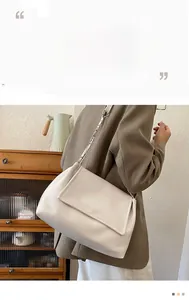 Detail of off-white shoulder bag with silver chain strap and magnetic flap closure