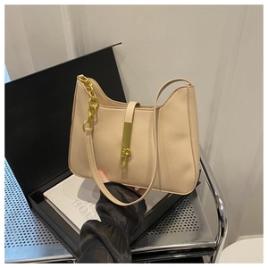 Détail du sac beige avec une boucle rectangulaire en métal doré et des accents de chaîne