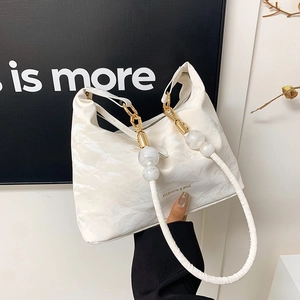 Minimalist white ruched tote bag with golden hardware and unique frosted bead handles
