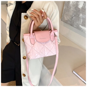 Close-up of pink quilted bucket bag with top handle and fashion text detail