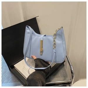 Gros plan sur un sac hobo bleu clair avec fermoir doré élégant et détail de chaîne