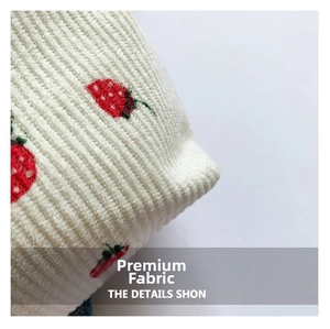 Macro detail of soft corduroy fabric with premium strawberry embroidery patterns
