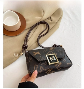 Detail of coffee brown crossbody bag with letter print and gold-tone M buckle