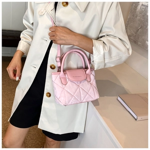 Detail view of pink quilted bucket bag with circular handle and fashion logo lettering