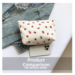 Close-up of white corduroy makeup bag featuring a cute red strawberry print and zipper
