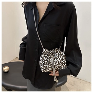 Close-up of leopard print bucket bag with silver chain strap and pearl charms