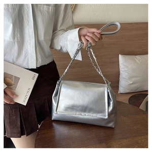 Detail of silver metallic tote bag featuring pleated texture and chain leather shoulder strap