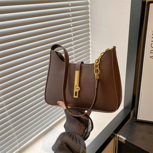Sac sous le bras marron foncé avec bordure ondulée, chaîne dorée et boucle sur fond naturel