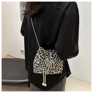 Detailed view of leopard print bucket bag with metal chain strap and pearl drawstring