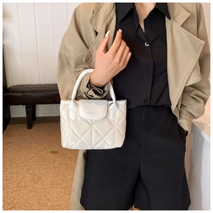 Elegant white quilted bucket bag with a glossy finish and stylish curved handle