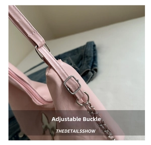 Detailed view of adjustable silver buckle and metal chain strap on pink shoulder bag
