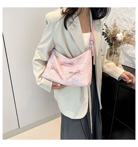 Pink shoulder bag with quilted texture, colorful embroidery, and cute ribbon bow detail