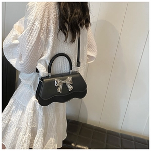 Sac bandoulière noir tendance avec grand nœud argenté et détails de bordure ondulée
