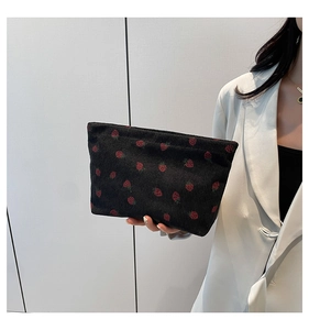 Detail of strawberry print on black corduroy tote bag featuring a smooth metal zipper