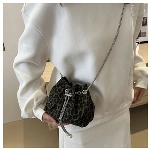 Close-up of leopard print bucket bag featuring silver chain strap and drawstring closure