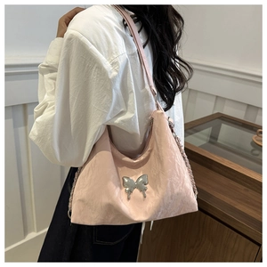 Detail of pink shoulder bag featuring silver butterfly buckle and metallic chain