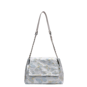 Elegant silver fabric shoulder bag with detailed blue and gold butterfly embroidery